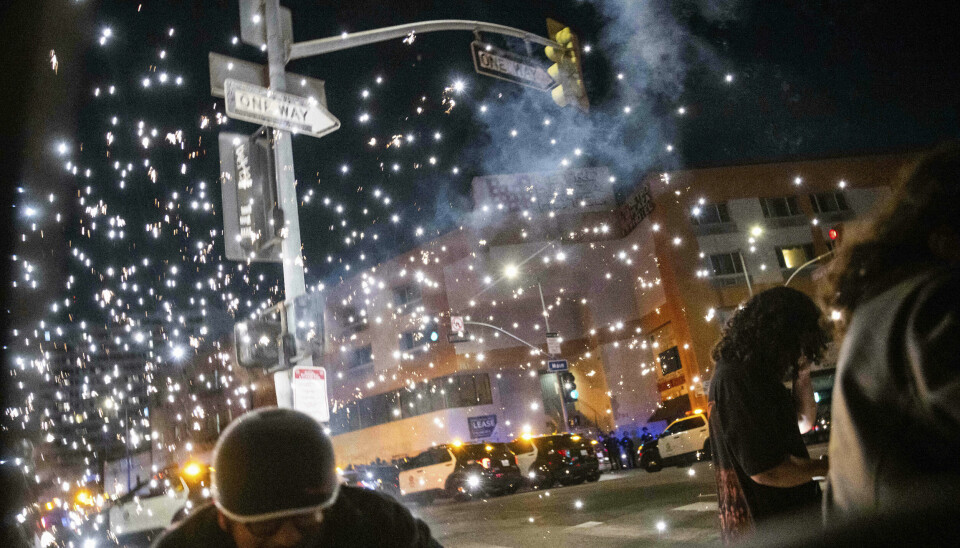 Folk søker dekning etter et eksplosjon nær Metropolitan Detention Center, en føderal bygning i sentrum av Los Angeles, søndag.